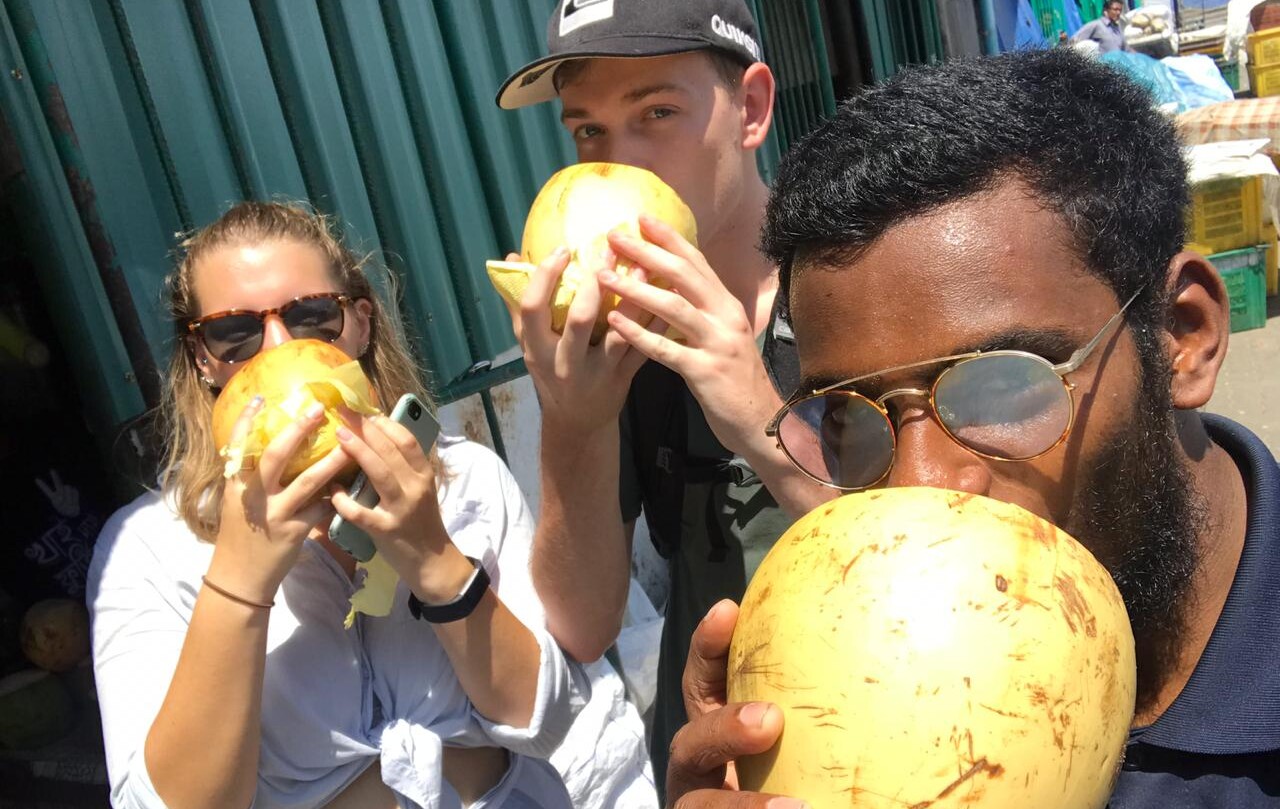 Local and tourists in the Maldives drinking from coconuts