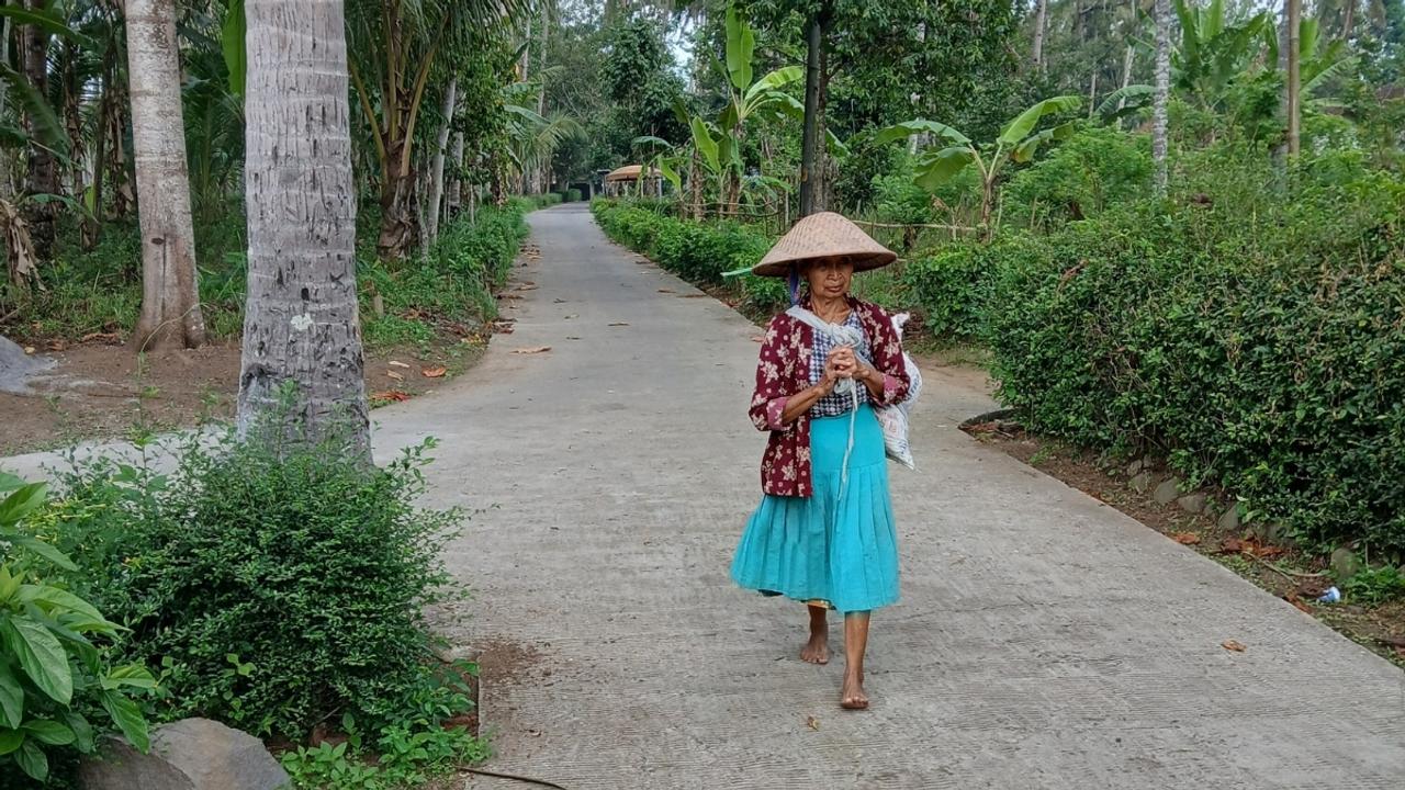Woman walking through garden Indonesia